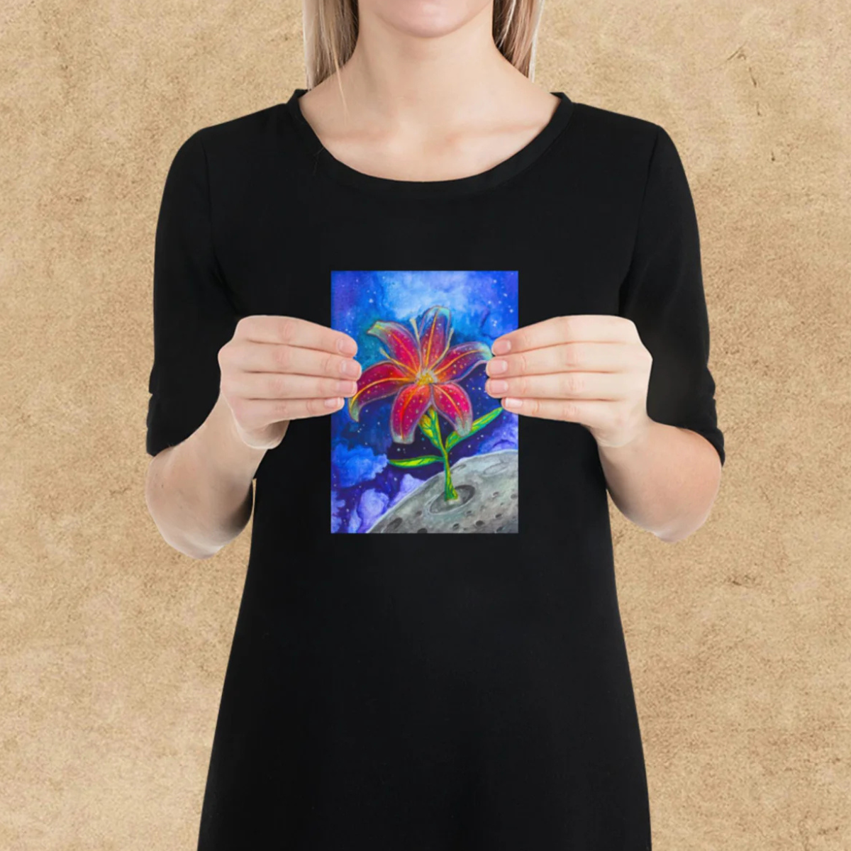 Person holding a colorful painting of a flower against a beige background
