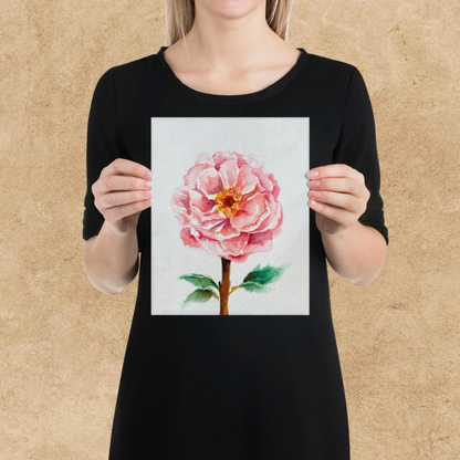 Person holding a print of a pink flower with a brown background