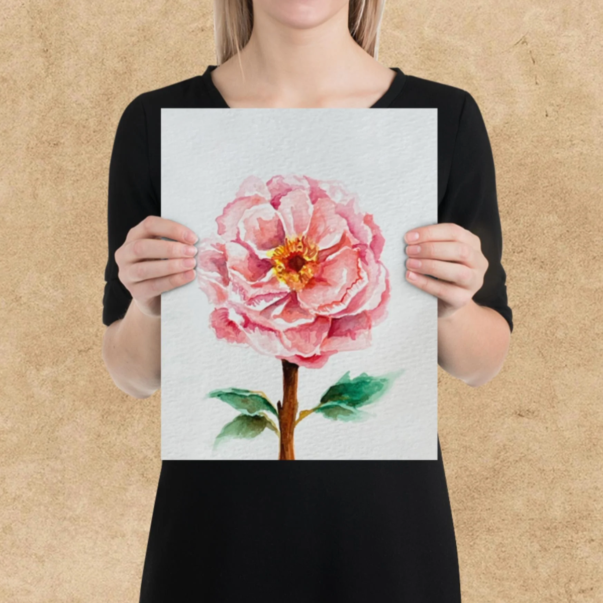Person holding a painting of a pink flower against a beige background